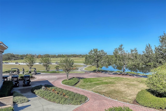 view of property's community with a lawn and a water view