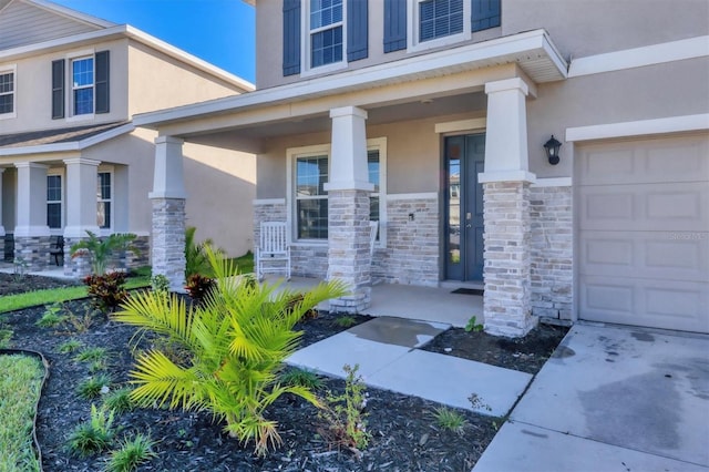 entrance to property featuring covered porch and a garage