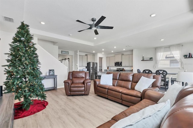 living room featuring ceiling fan and light wood-type flooring