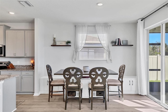 dining area with plenty of natural light and light wood-type flooring