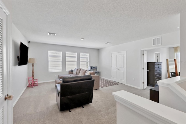 living room with a textured ceiling and light colored carpet