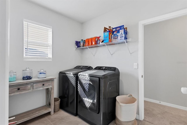 clothes washing area with light tile patterned floors and washer and dryer