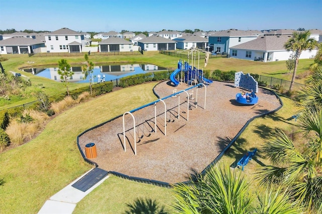 view of home's community with a playground, a lawn, and a water view