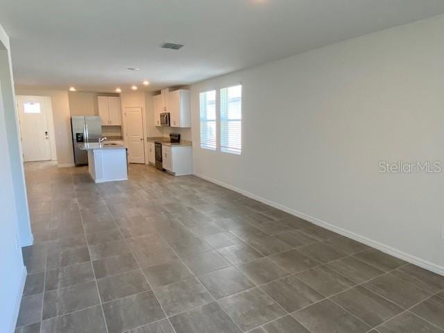 kitchen with white cabinetry, a center island, and stainless steel appliances