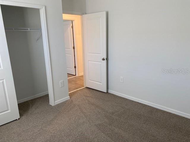 unfurnished bedroom featuring a closet and carpet floors