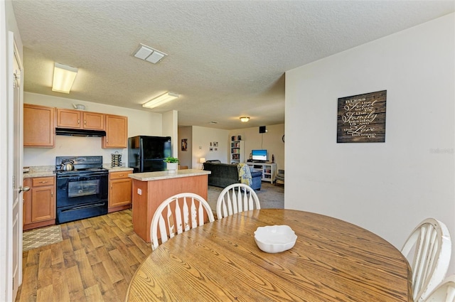 dining room featuring light hardwood / wood-style floors and a textured ceiling