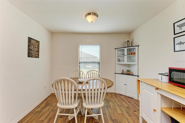 dining room featuring a textured ceiling and light hardwood / wood-style flooring