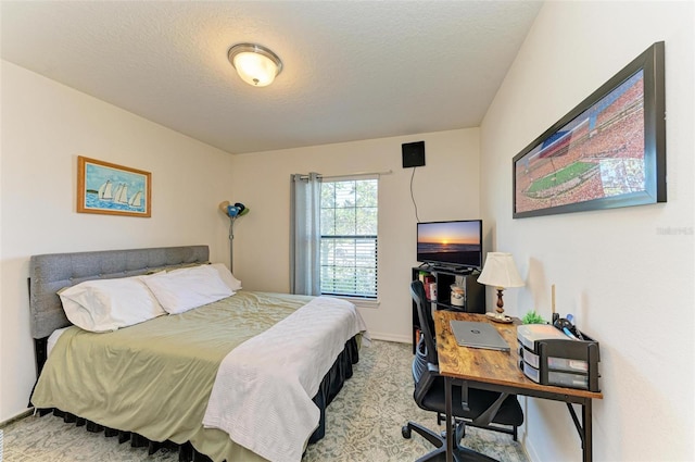 bedroom featuring light carpet and a textured ceiling