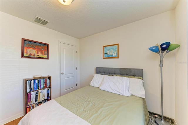 bedroom with hardwood / wood-style floors and a textured ceiling