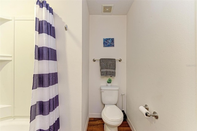 bathroom featuring a shower with curtain, hardwood / wood-style flooring, and toilet