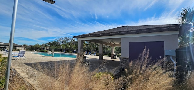 view of swimming pool featuring ceiling fan and a patio