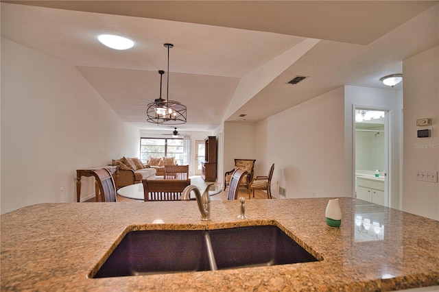 kitchen with sink, hanging light fixtures, and vaulted ceiling