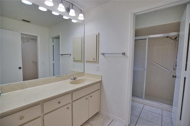 bathroom with tile patterned floors, vanity, and a shower with door