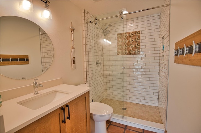 bathroom with tile patterned flooring, a tile shower, vanity, and toilet