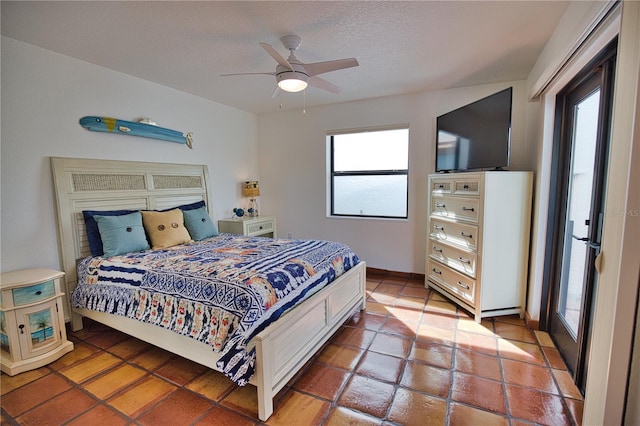 tiled bedroom featuring ceiling fan and a textured ceiling