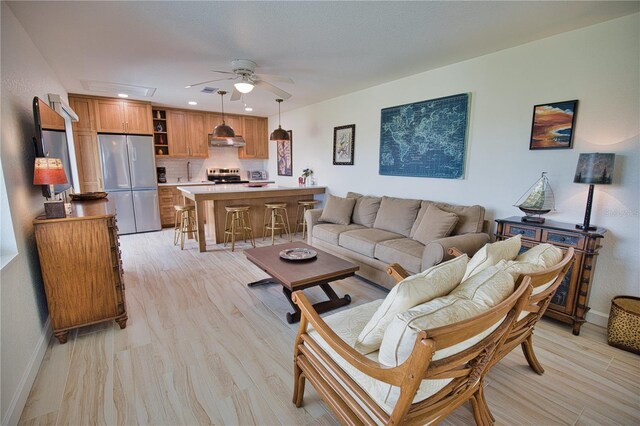 living room with ceiling fan and light wood-type flooring