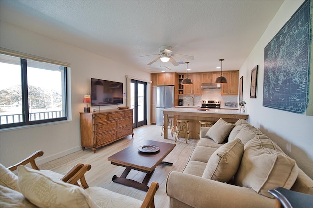 living room with ceiling fan, sink, and light hardwood / wood-style flooring