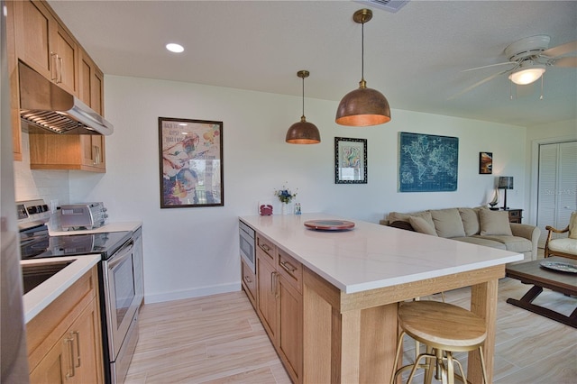 kitchen with a kitchen breakfast bar, kitchen peninsula, stainless steel appliances, and range hood