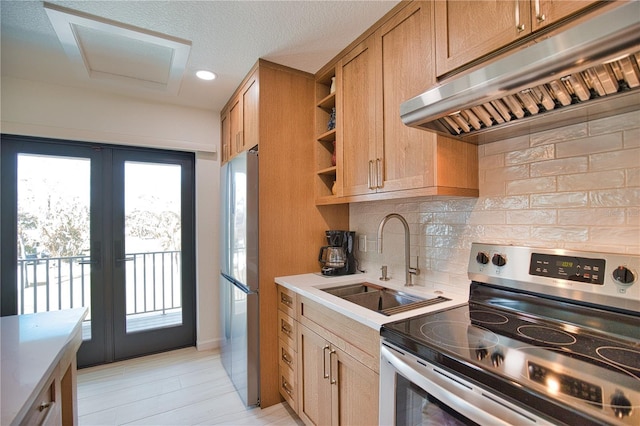 kitchen featuring french doors, light wood-type flooring, tasteful backsplash, stainless steel appliances, and sink