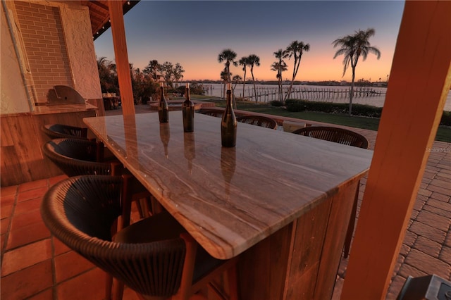 patio terrace at dusk featuring a bar