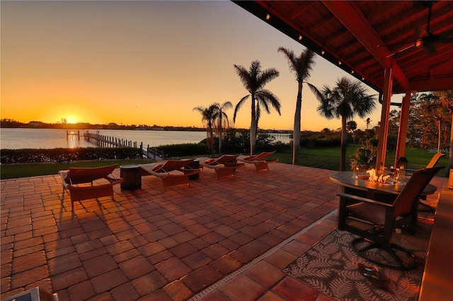 patio terrace at dusk featuring a water view