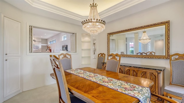 dining area with light carpet, a chandelier, a wealth of natural light, and ornamental molding