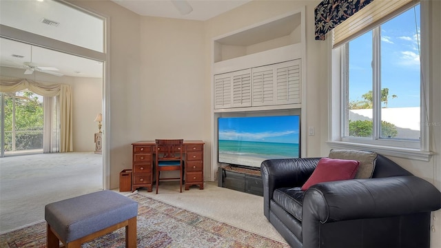 living room with a wealth of natural light, carpet, and ceiling fan