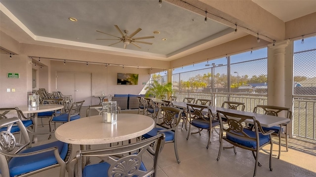 sunroom featuring a tray ceiling and ceiling fan