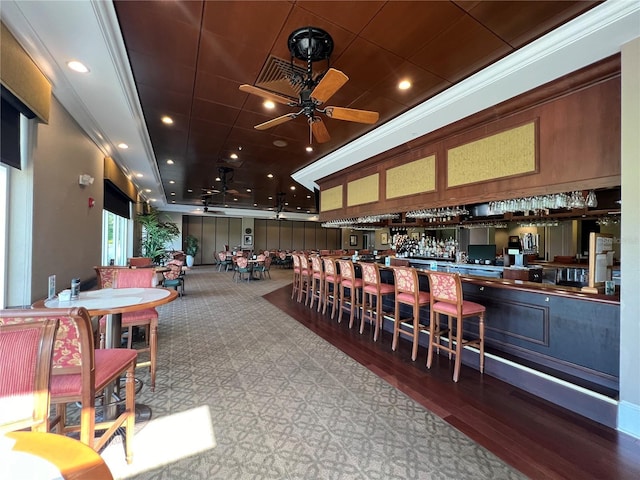 bar with hardwood / wood-style flooring, ceiling fan, and crown molding