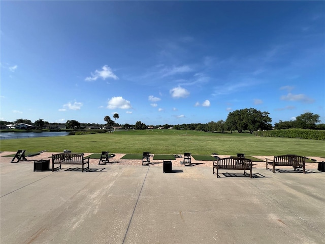 surrounding community featuring a lawn and a water view