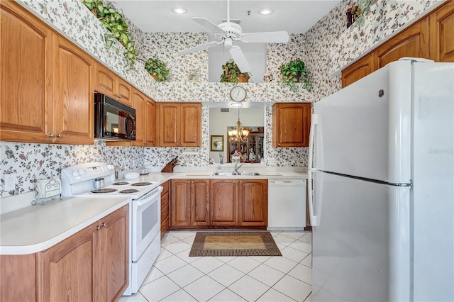 kitchen with sink, pendant lighting, white appliances, light tile patterned floors, and ceiling fan with notable chandelier