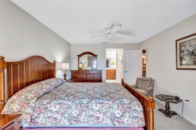 carpeted bedroom with ensuite bath and ceiling fan