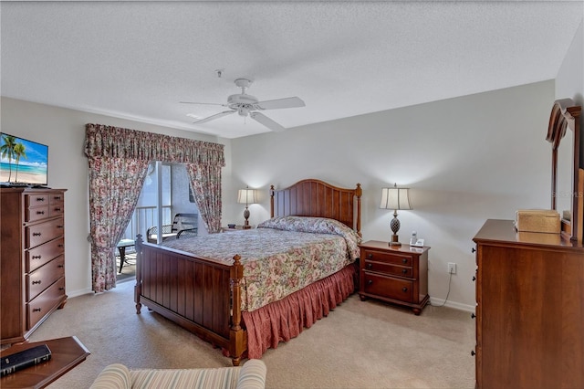 bedroom with ceiling fan, light colored carpet, and a textured ceiling