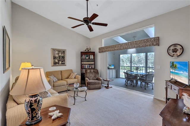 living room with ceiling fan, high vaulted ceiling, and light carpet