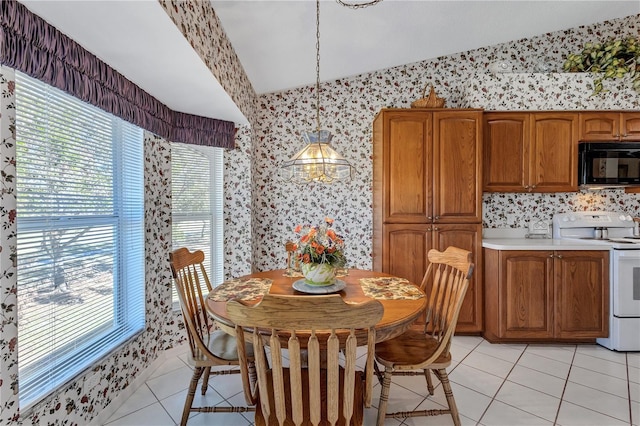 6713 Stone River Rd Unit 205, Bradenton, FL 34203 - dining space featuring wallpapered walls, vaulted ceiling, light tile patterned flooring, and plenty of natural light