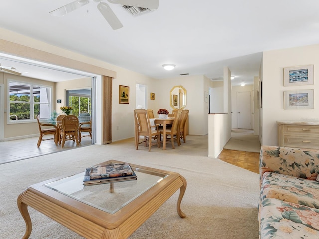 carpeted living room with ceiling fan