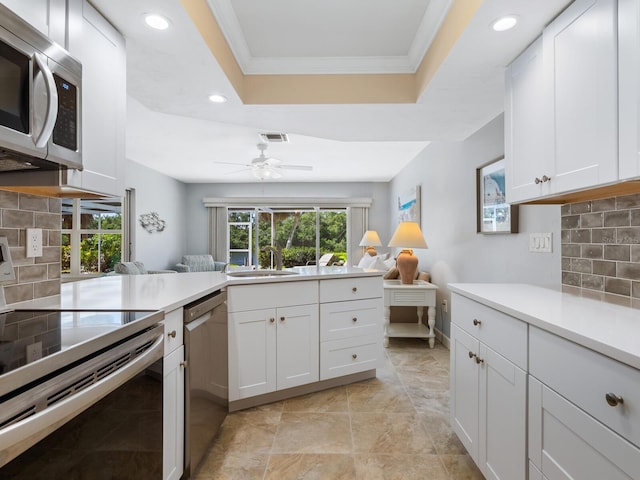 kitchen with backsplash, sink, white cabinets, and stainless steel appliances