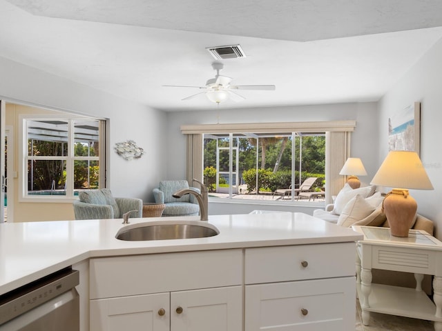 kitchen with white cabinetry, sink, white dishwasher, and ceiling fan