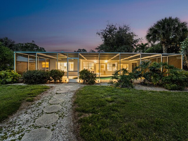 view of front of property with a lanai and a yard