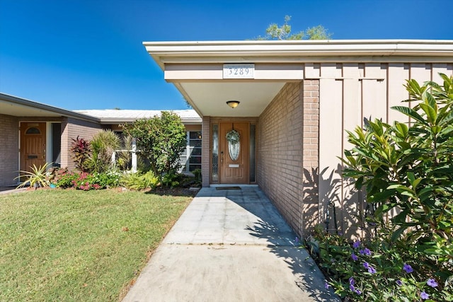 view of exterior entry with a lawn