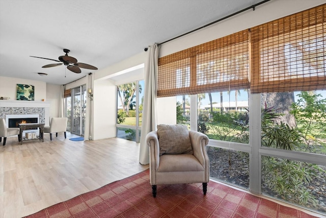 interior space featuring a fireplace, ceiling fan, and hardwood / wood-style floors