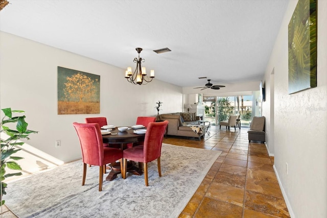 dining area featuring ceiling fan with notable chandelier