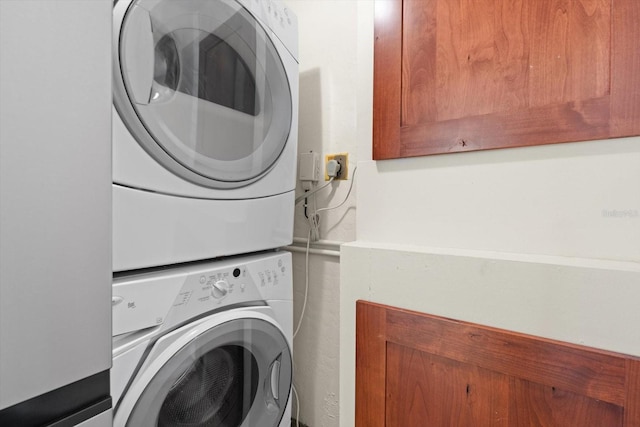 clothes washing area with stacked washer / dryer