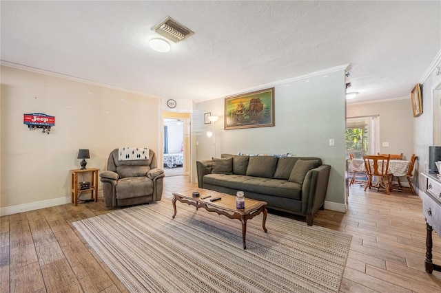 living room with ornamental molding, a textured ceiling, and light hardwood / wood-style flooring