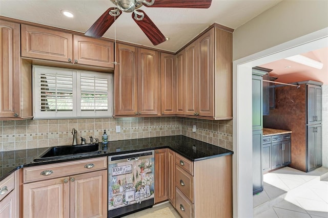 kitchen featuring backsplash, dishwasher, dark stone countertops, and sink