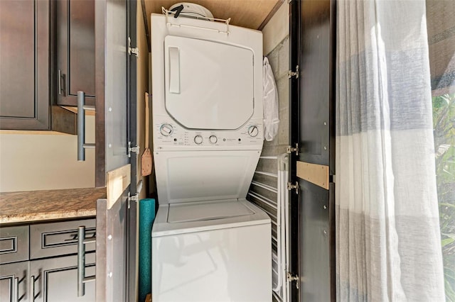 laundry room with stacked washing maching and dryer