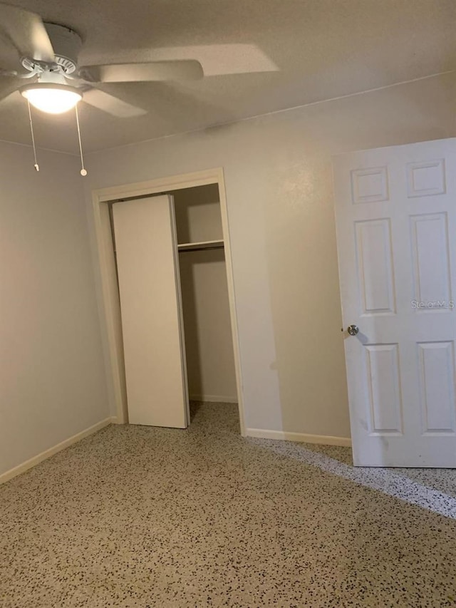 unfurnished bedroom featuring ceiling fan and a closet