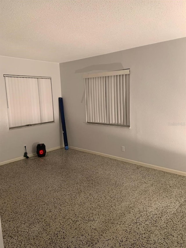 unfurnished room with a textured ceiling