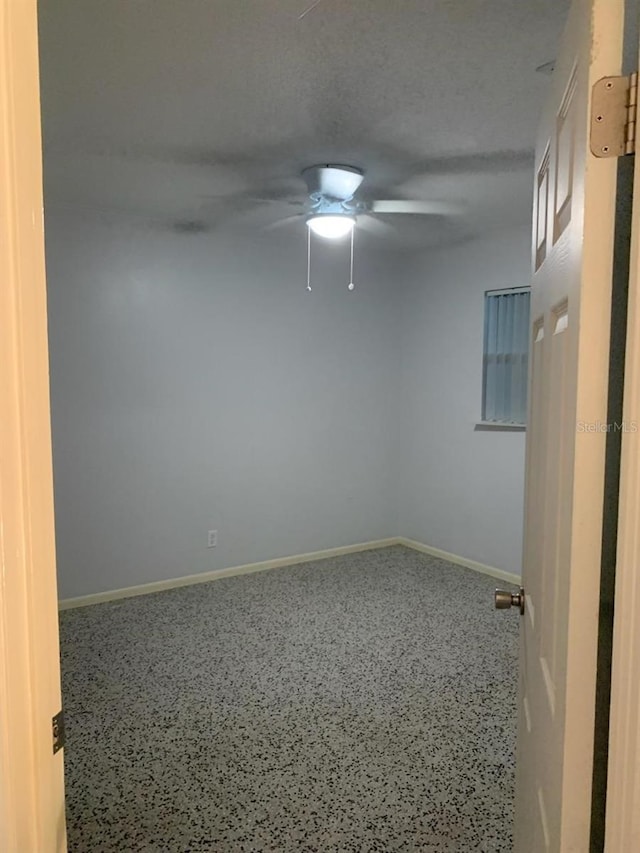 empty room with a textured ceiling and ceiling fan