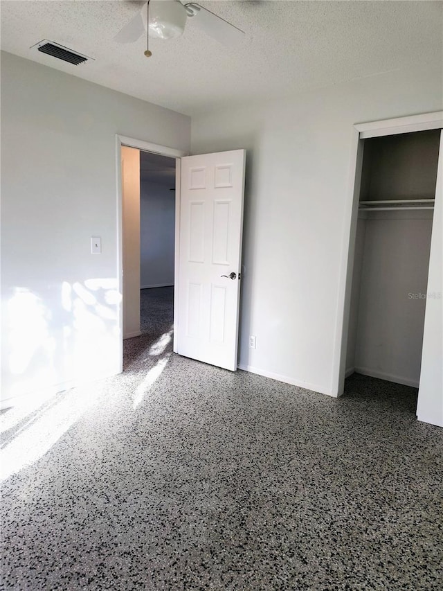 unfurnished bedroom with ceiling fan, a textured ceiling, and a closet